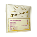 The Pull & Pour Shop Antonio Medina Guatemala whole bean coffee bag with gold foil branding on a soft peach background.