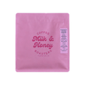 The Pull & Pour Shop Ethiopia Habtamu Gato coffee bag in pink packaging with a Milk & Honey neon sign above it.