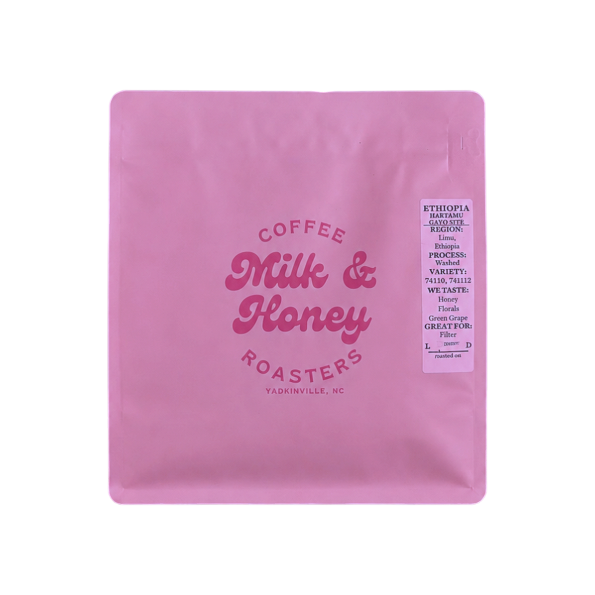 The Pull & Pour Shop Ethiopia Habtamu Gato coffee bag in pink packaging with a Milk & Honey neon sign above it.