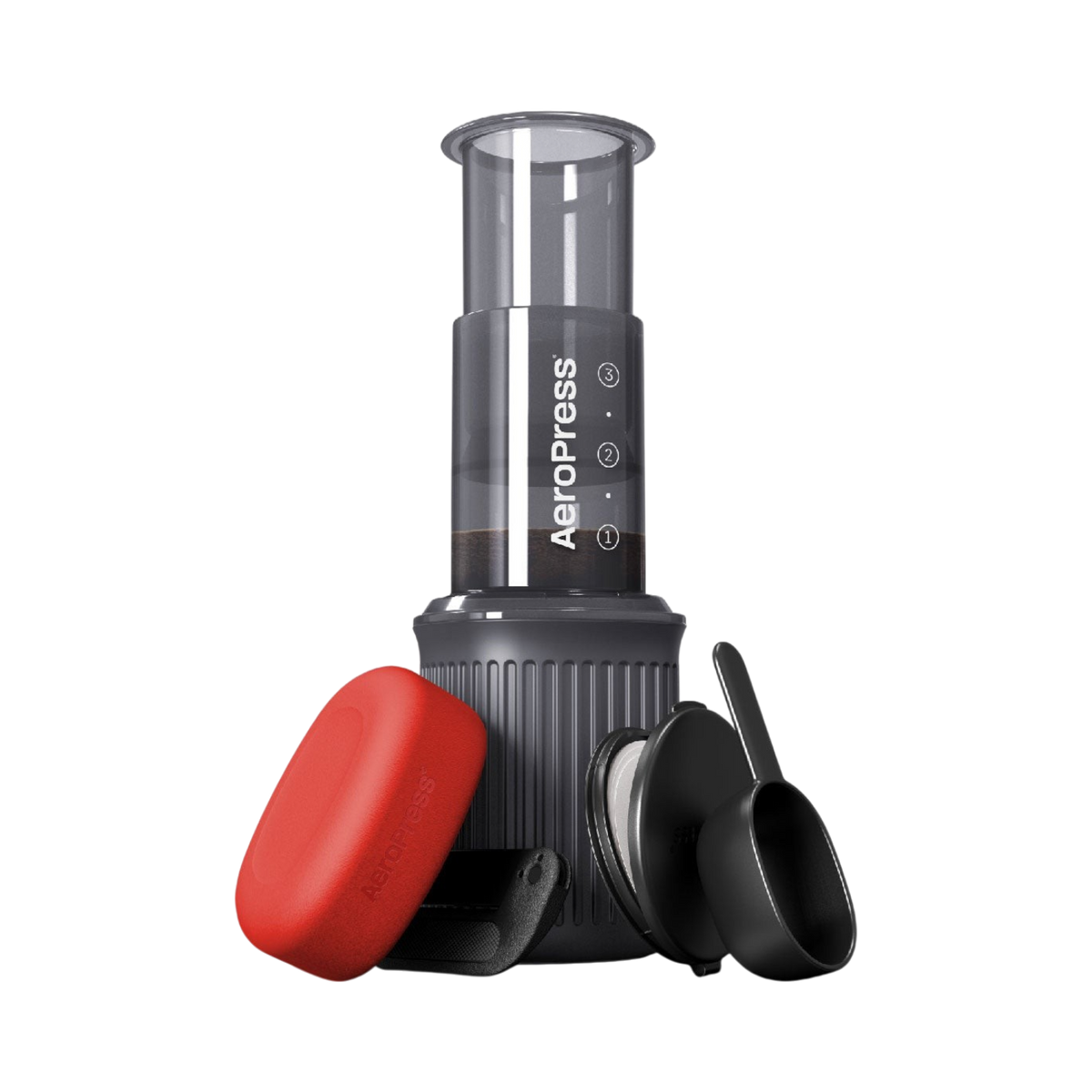 The Pull & Pour Shop AeroPress Go travel coffee maker with grey chamber, red filter case, scoop, and stirrer.