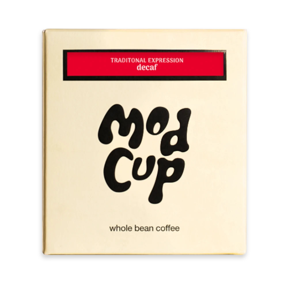 The Pull & Pour Shop medium-roast decaf coffee bag in gold packaging with bold black branding and red label detail.